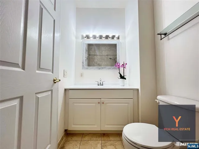 a bathroom with a sink vanity mirror and toilet
