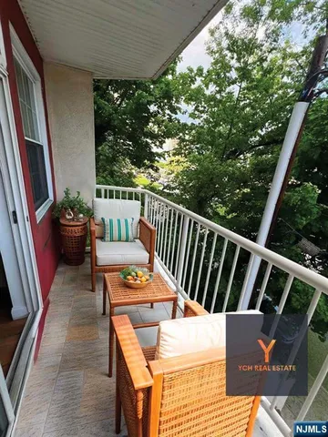 a balcony with wooden floor and outdoor seating