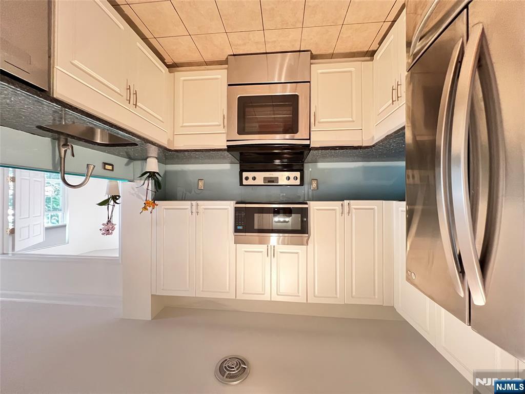 1100 River Road, Unit 206 Edgewater, NJ 07020 - Photo 3 of 13 a kitchen with stainless steel appliances granite countertop a refrigerator sink and stove