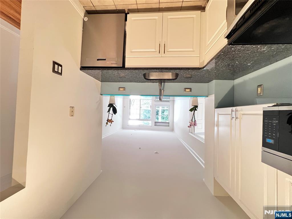 1100 River Road, Unit 206 Edgewater, NJ 07020 - Photo 4 of 13 a kitchen with granite countertop a sink a stove and cabinets