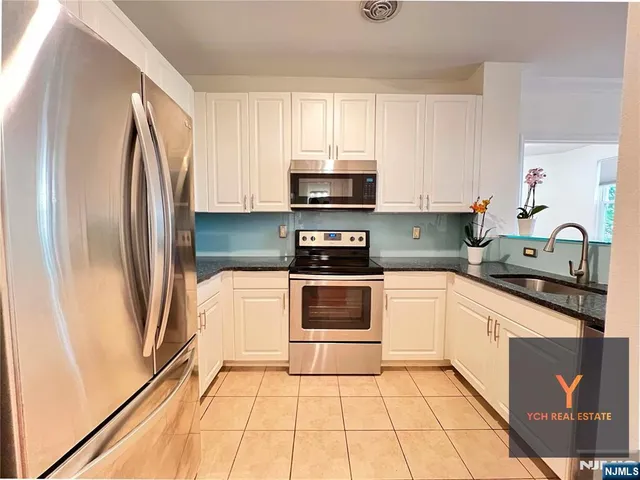 a kitchen with a refrigerator a microwave a sink and cabinets