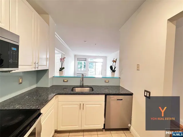 a kitchen with stainless steel appliances granite countertop a sink a stove and a microwave