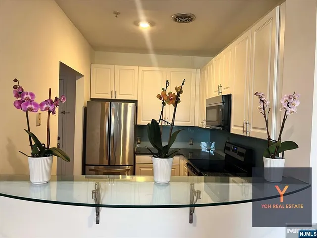 a kitchen with a potted plant on the counter and a window