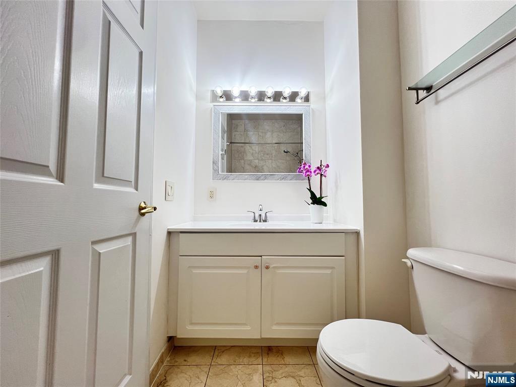 1100 River Road, Unit 206 Edgewater, NJ 07020 - Photo 9 of 13 a bathroom with a sink vanity mirror and toilet