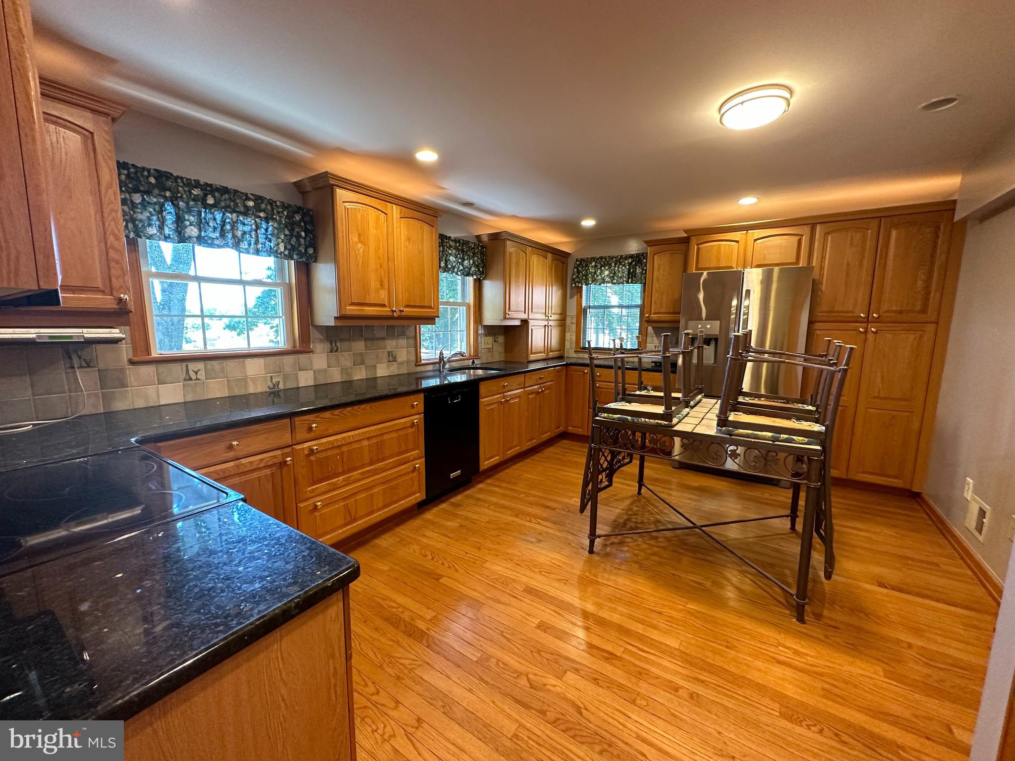 64 Warrior Road Drexel Hill, PA 19026 - Photo 4 of 11 a kitchen with stainless steel appliances granite countertop sink stove and wooden cabinets