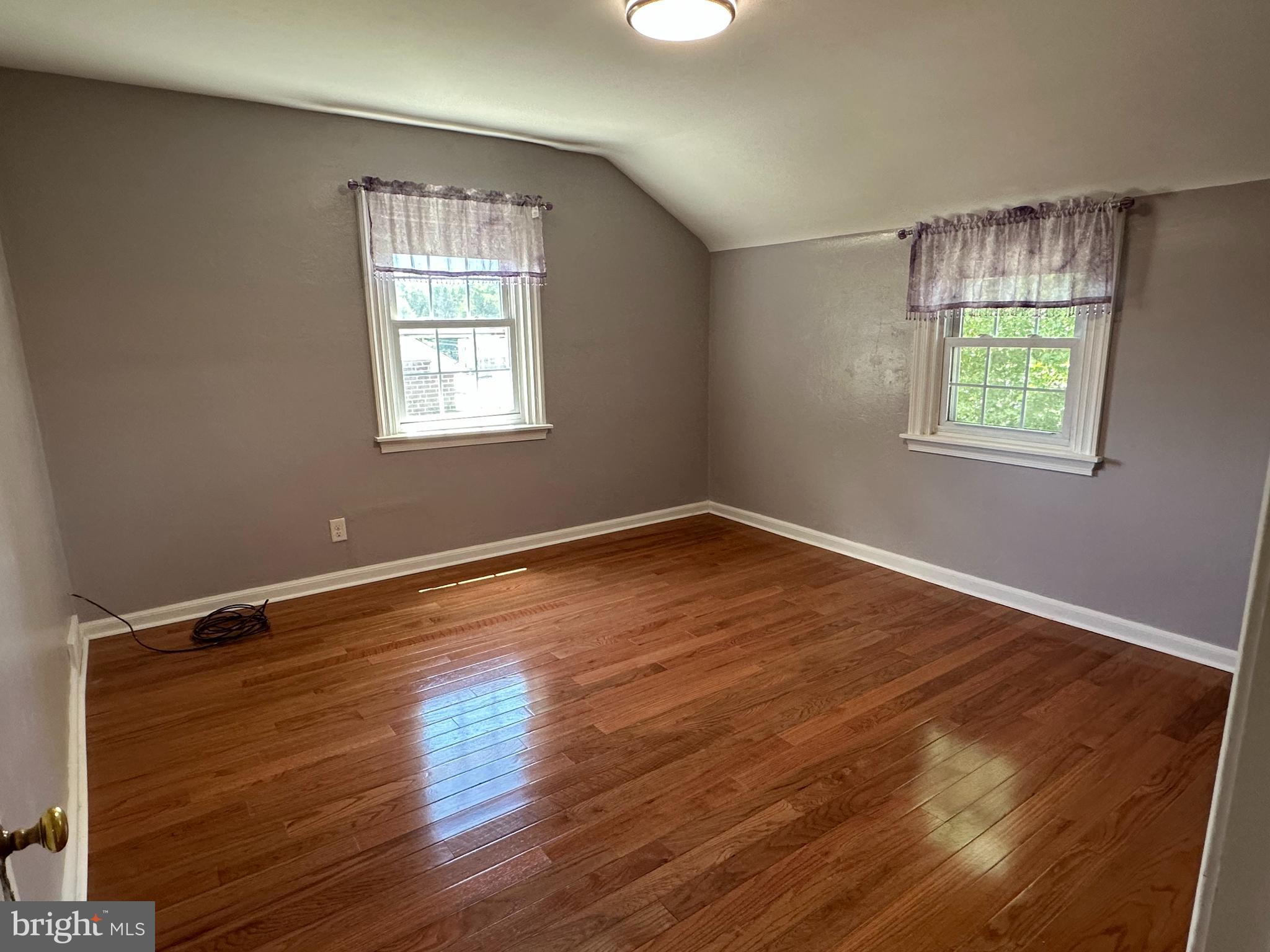 64 Warrior Road Drexel Hill, PA 19026 - Photo 8 of 11 an empty room with wooden floor and windows