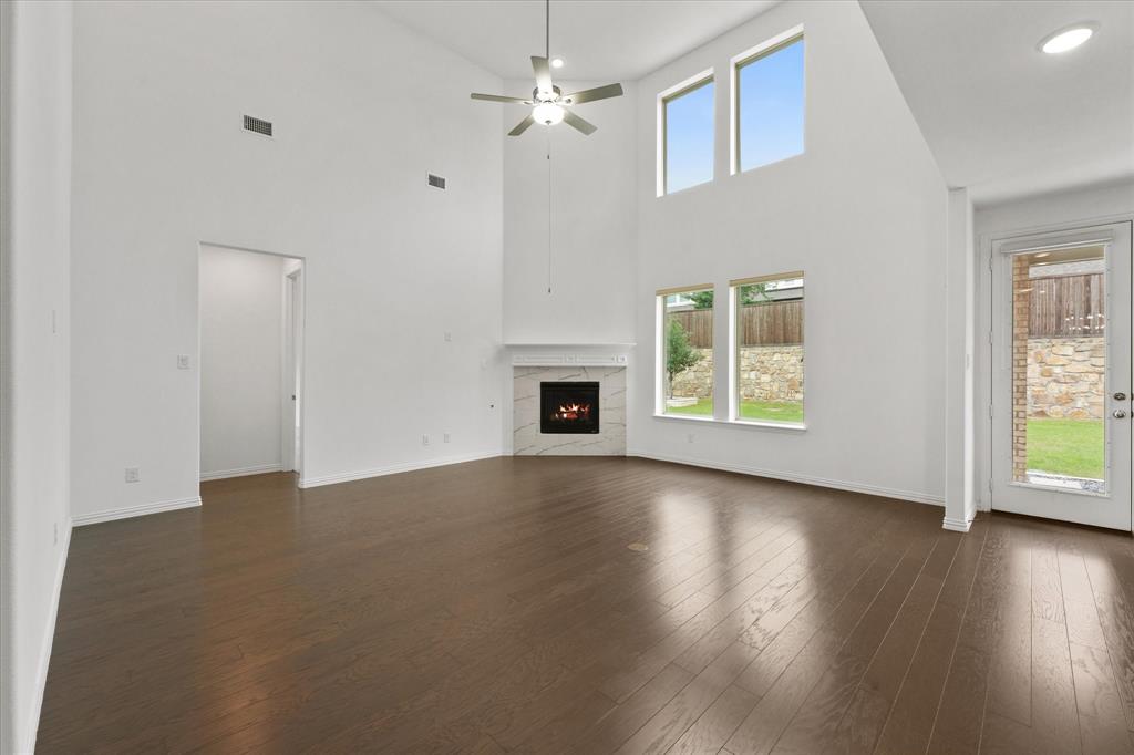3533 Hyacinth Way Prosper, TX 75078 - Photo 13 of 38 an empty room with wooden floor chandelier fan and windows