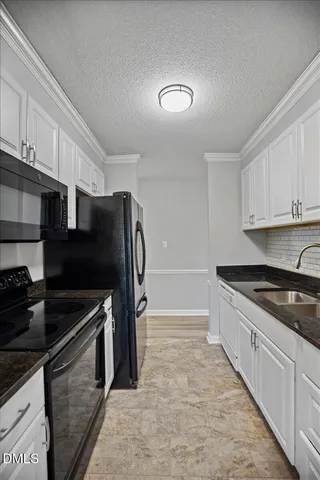 a kitchen with a sink and a stove top oven with wooden floor