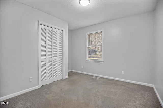 a view of an empty room and closet area