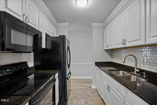 a kitchen with granite countertop a refrigerator and a sink