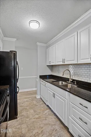 a kitchen with granite countertop a refrigerator and a sink