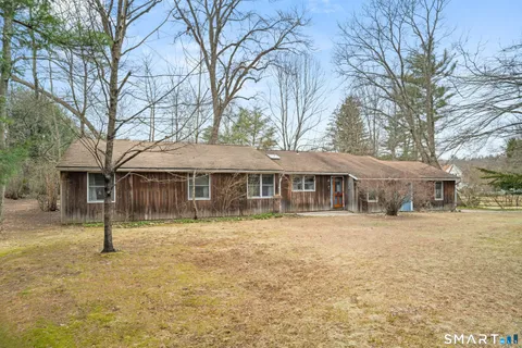 a backyard of a house with barbeque oven fire pit table and chairs