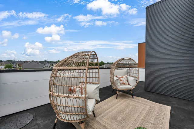 a view of a roof deck with chair and table