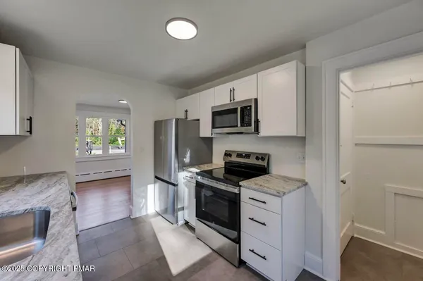 a kitchen with white cabinets and stainless steel appliances