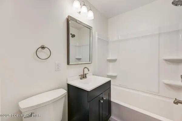 a bathroom with a toilet sink vanity and mirror