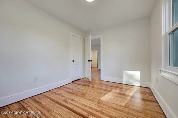 a view of empty room with wooden floor