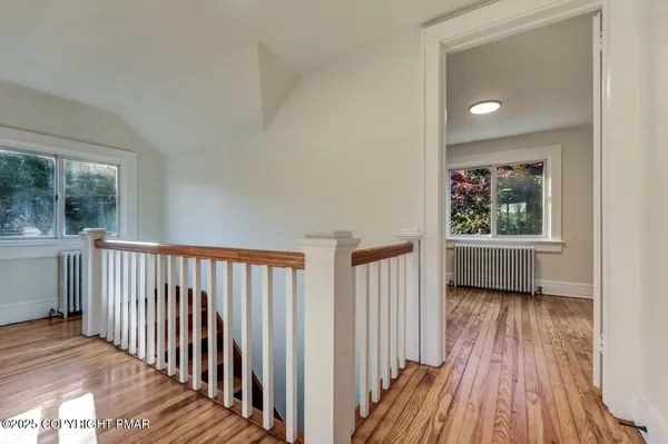 a view of a hallway with wooden floor and a window