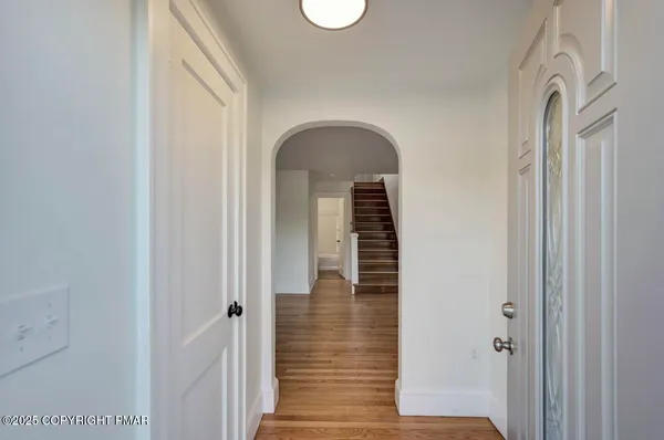 a view of a hallway with wooden floor and staircase