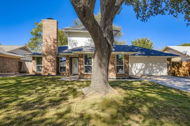 a front view of a house with a garden and yard