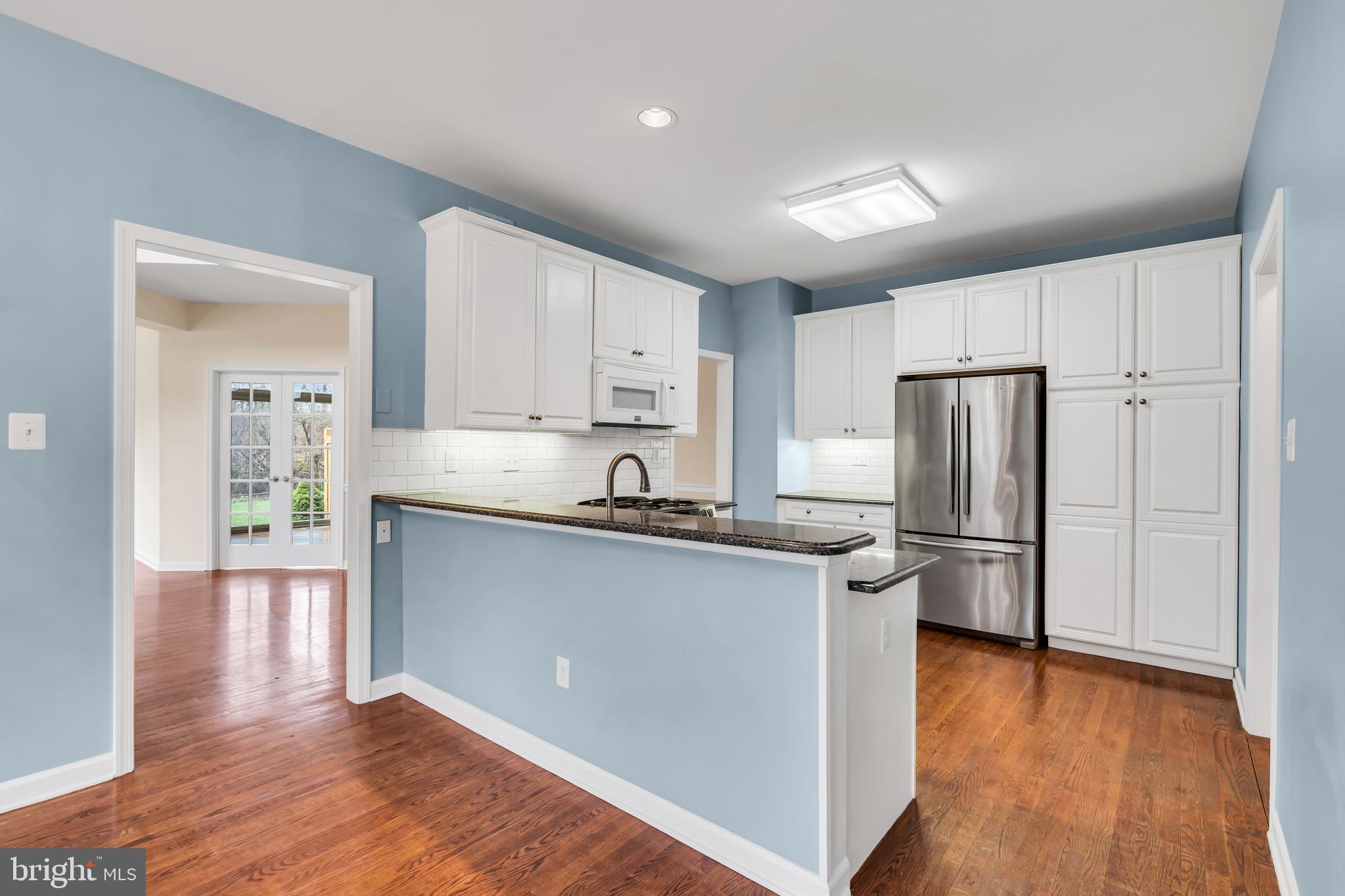 21 Wilkinson Way Princeton, NJ 08540 - Photo 11 of 43 a kitchen with stainless steel appliances granite countertop a refrigerator a sink a stove and white cabinets with wooden floor