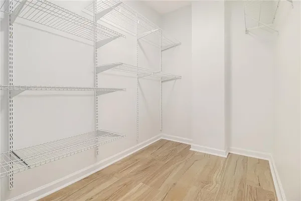 a view of an empty walk in closet with wooden floor