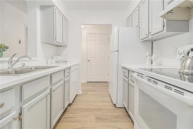 a kitchen with cabinets appliances a sink and a counter top