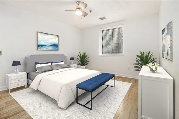 a bedroom with a large bed and a potted plant