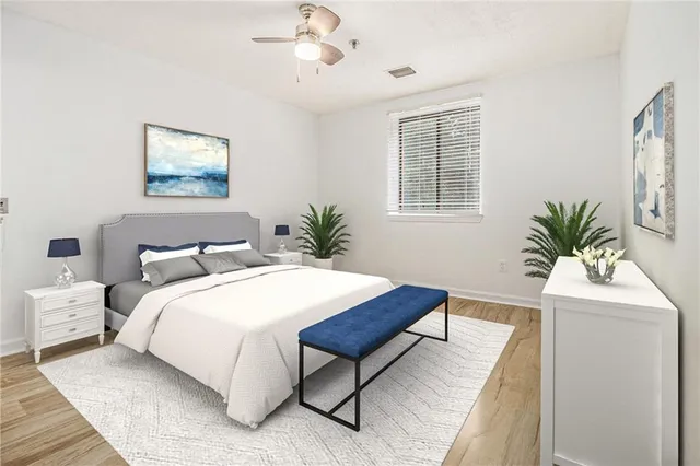 a bedroom with a large bed and a potted plant