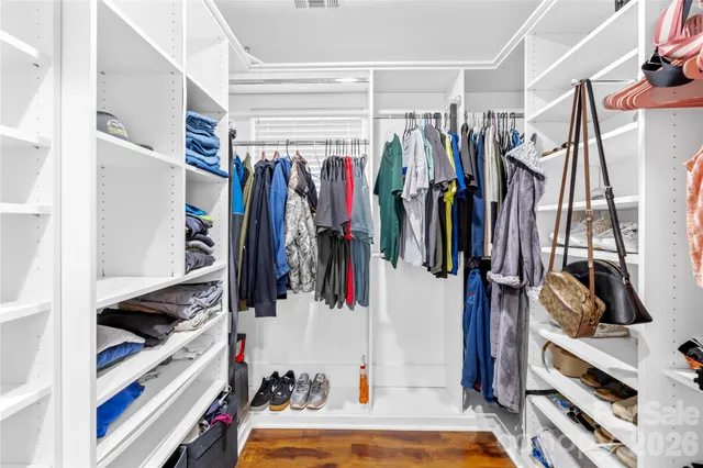 a view of walk in closet with clothes and shoes