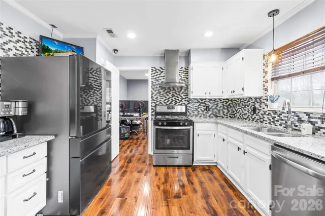 a kitchen with stainless steel appliances kitchen island granite countertop a refrigerator and a stove top oven