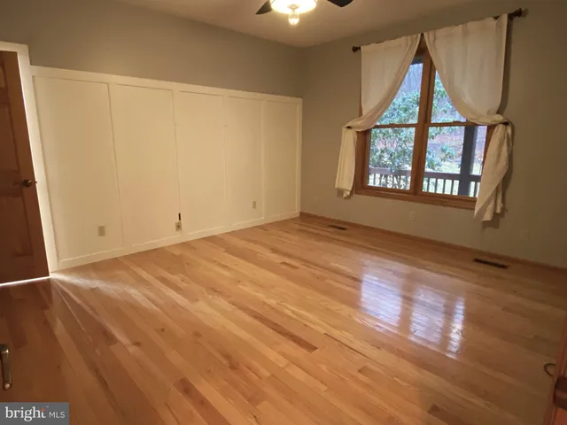 wooden floor in an empty room with a window