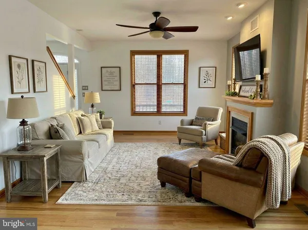 a living room with furniture a fireplace and a flat screen tv