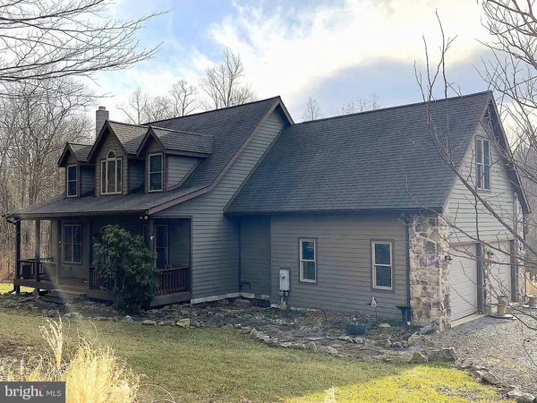 a view of a house with swimming pool next to a yard