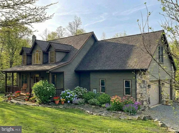 a front view of a house with a yard and potted plants