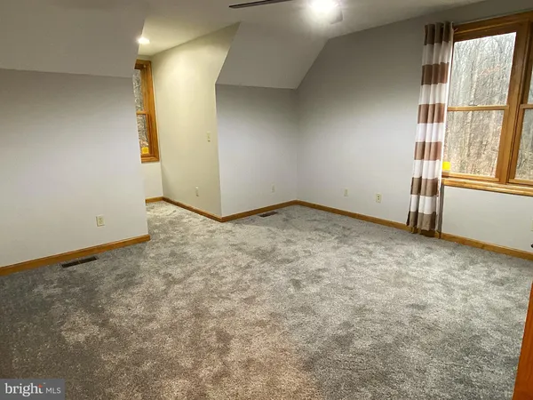 a bedroom with a bed and glass walk in closet