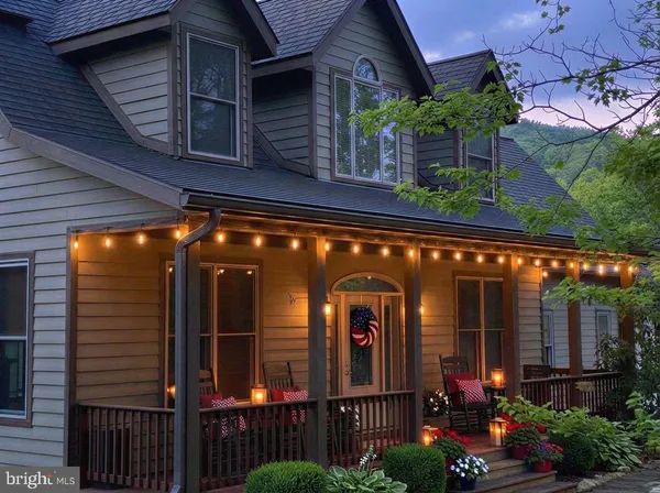 a view of a house with large windows and flower plants