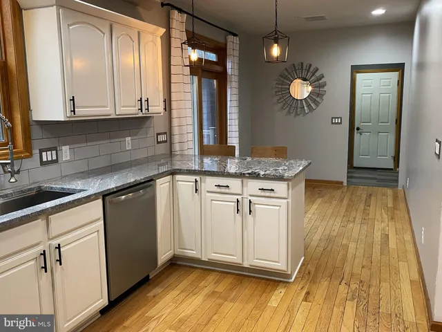 a kitchen with granite countertop a sink stainless steel appliances and cabinets