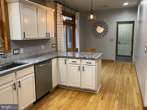 a view of a dining room with furniture a chandelier and wooden floor