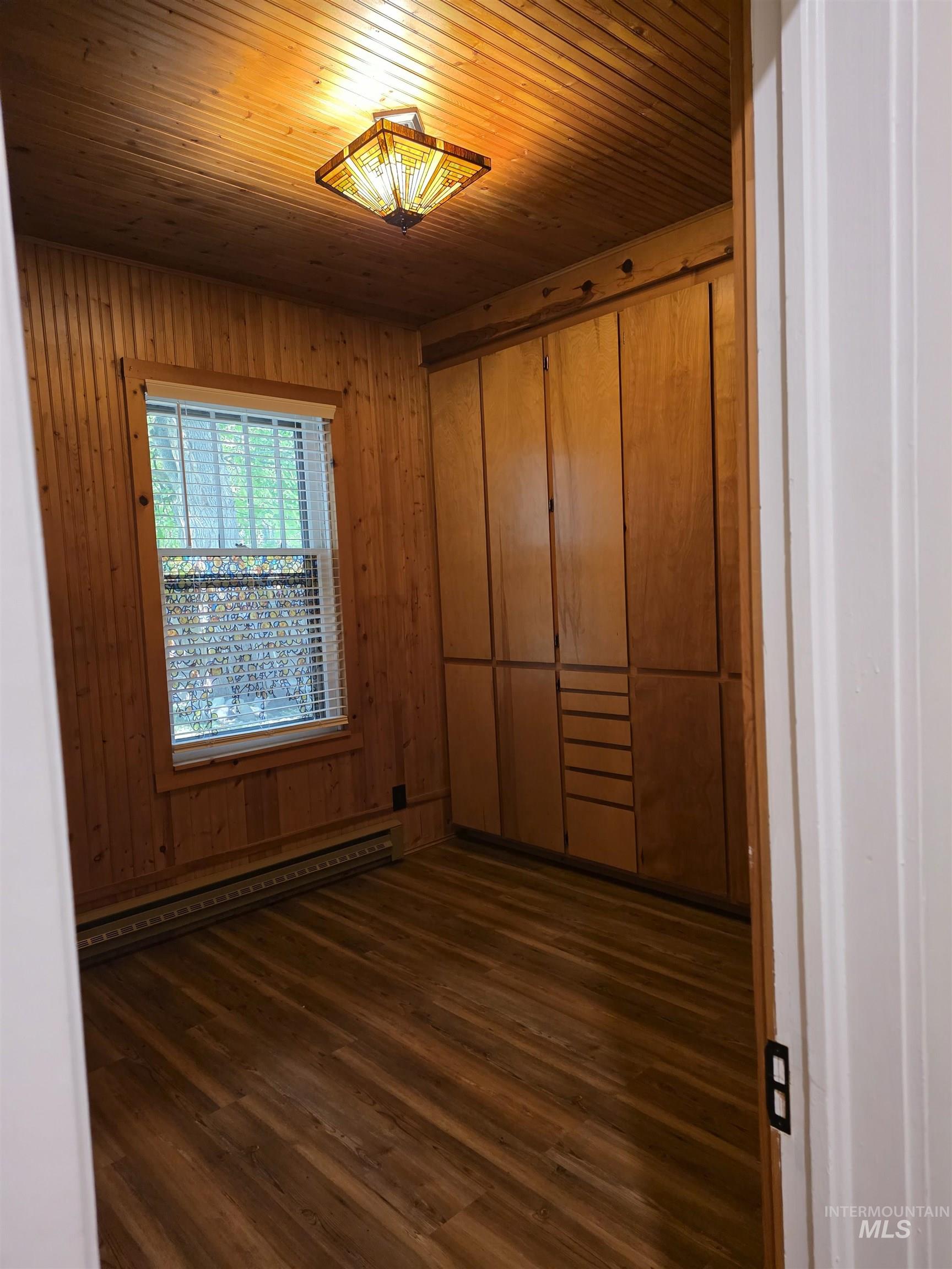 421 East Main Street Jerome, ID 83338 - Photo 8 of 13 Corner kitchen featuring wood cabinetry, light-toned countertops, a full tile backsplash, a stainless steel refrigerator, and dark-finish appliances