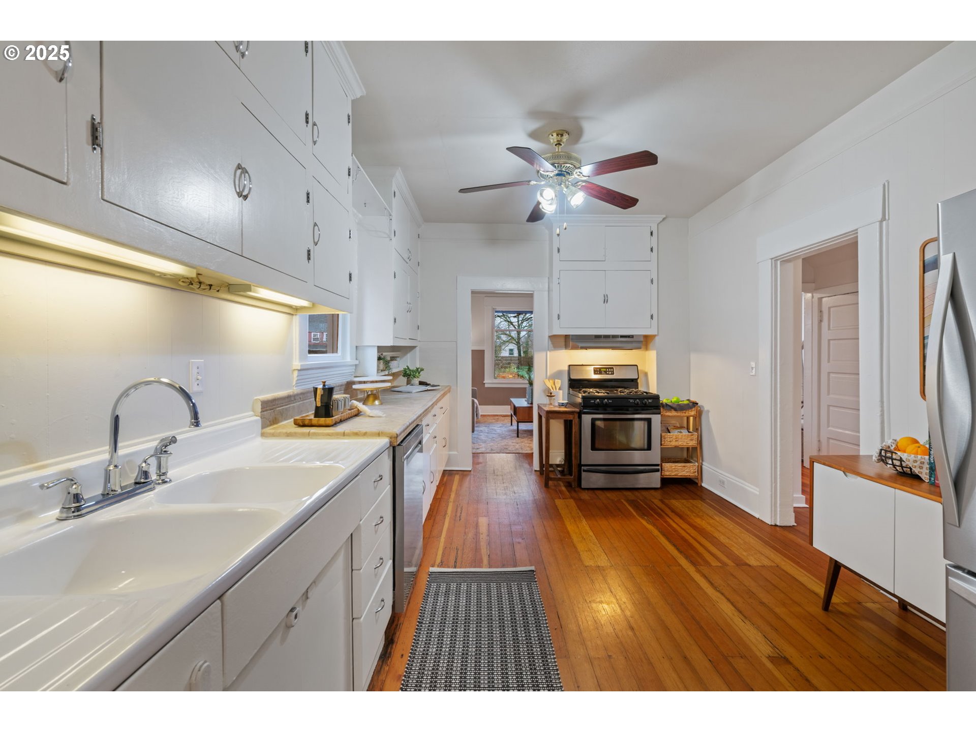 5415 Northeast 14th Place Portland, OR 97211 - Photo 11 of 38 a open kitchen with stainless steel appliances granite countertop a refrigerator a sink dishwasher a stove and a dining table with wooden floor