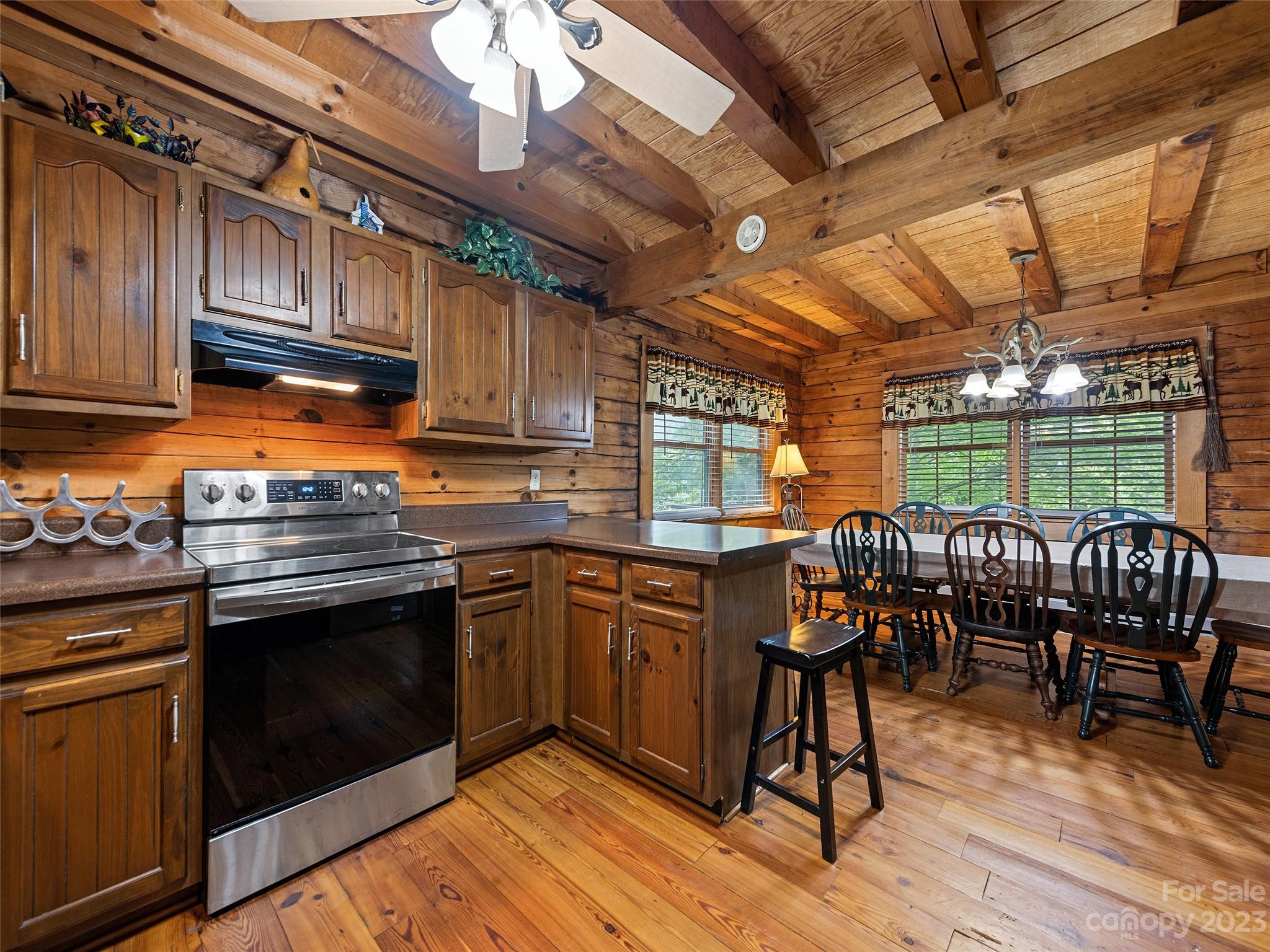 81 Railroad Grade Road Maggie Valley, NC 28751 - Photo 11 of 38 a kitchen with granite countertop wooden floors a stove and white stainless steel appliances