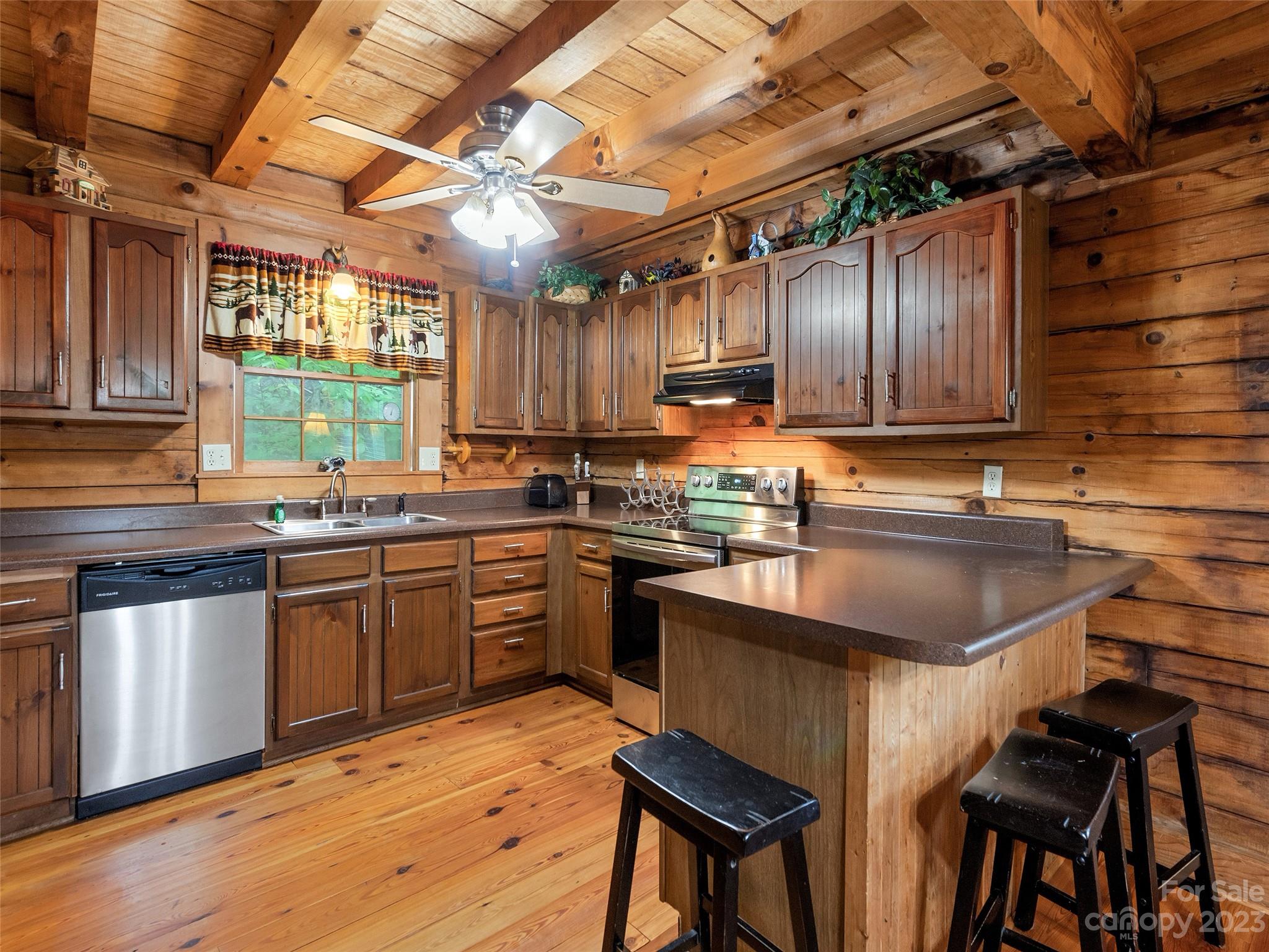 81 Railroad Grade Road Maggie Valley, NC 28751 - Photo 12 of 38 a kitchen with kitchen island granite countertop wooden cabinets a sink and a stove
