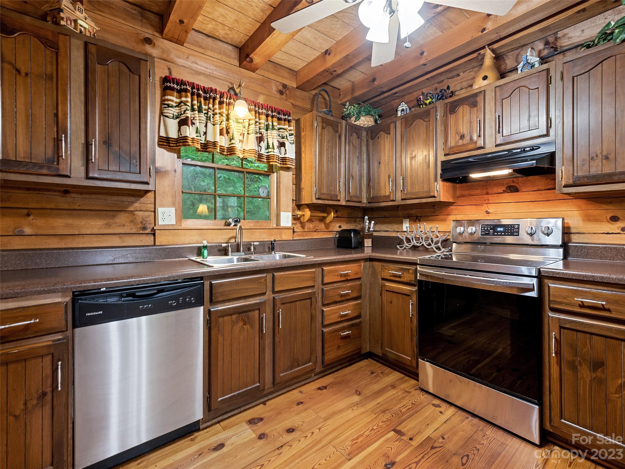 81 Railroad Grade Road Maggie Valley, NC 28751 - Photo 13 of 38 a kitchen with stainless steel appliances granite countertop a stove a sink dishwasher and cabinets with wooden floor