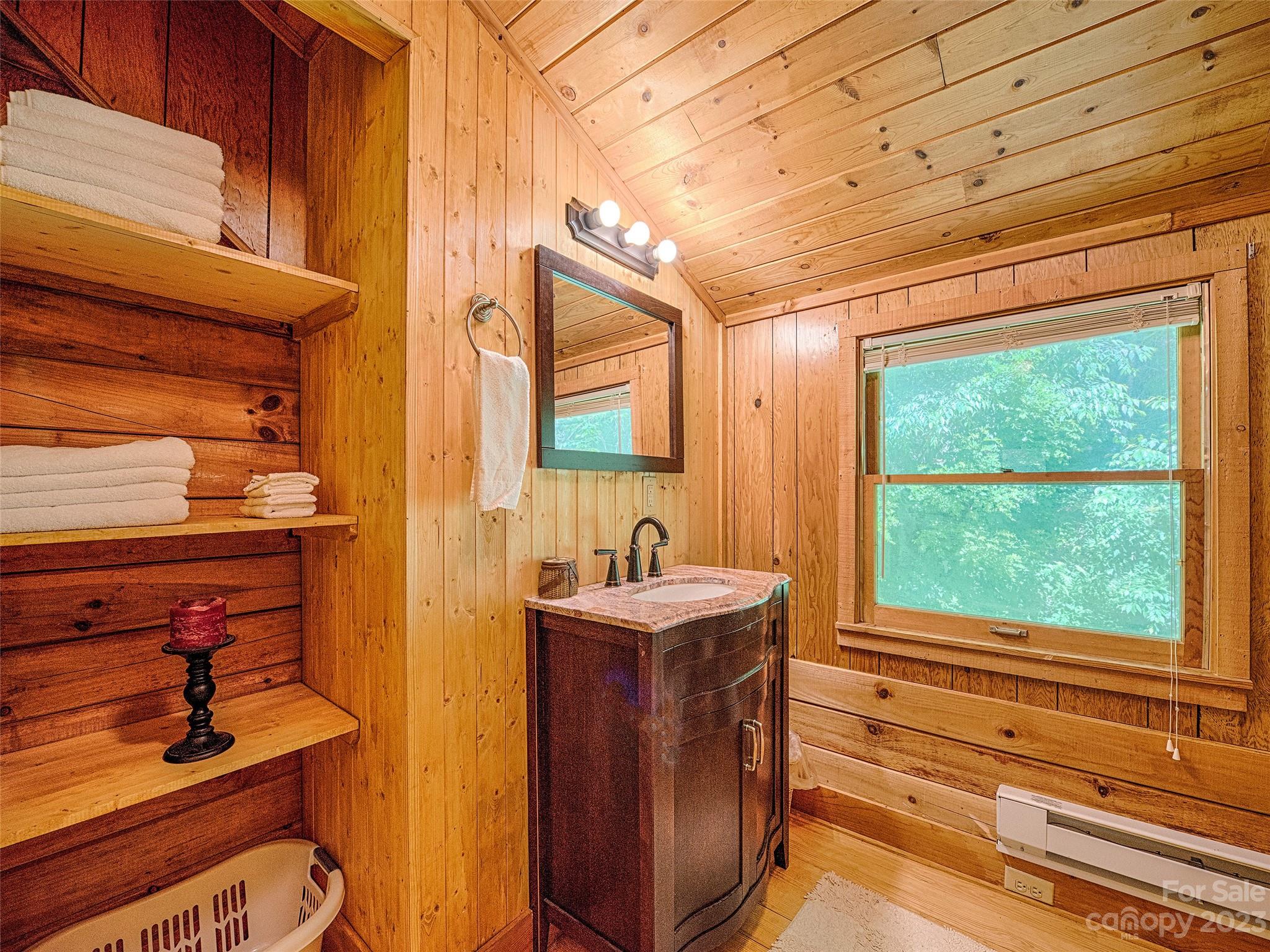 81 Railroad Grade Road Maggie Valley, NC 28751 - Photo 17 of 38 a bathroom with a sink a mirror and next to a window