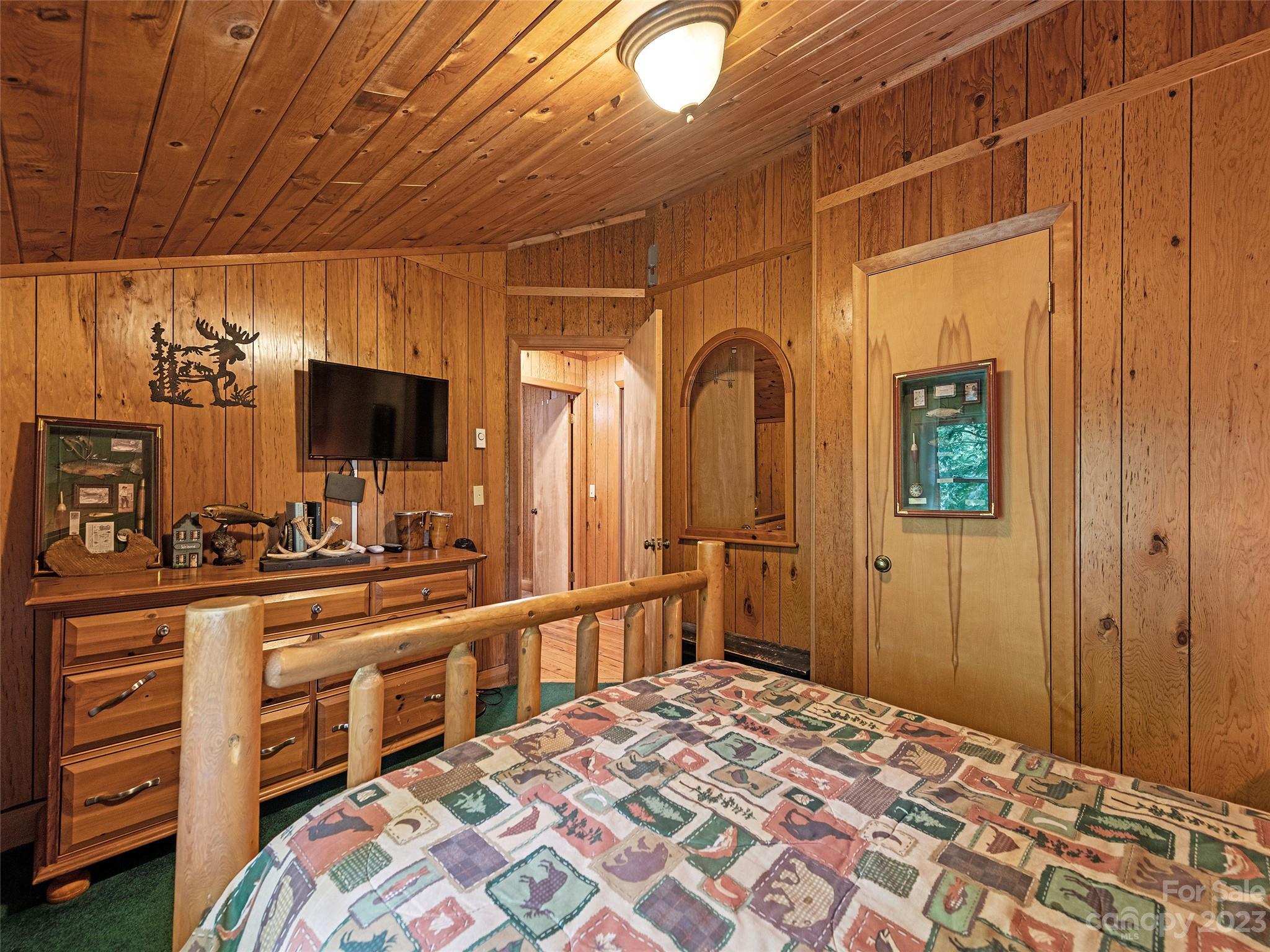 81 Railroad Grade Road Maggie Valley, NC 28751 - Photo 25 of 38 a bedroom with a bed and a flat tv screen in it