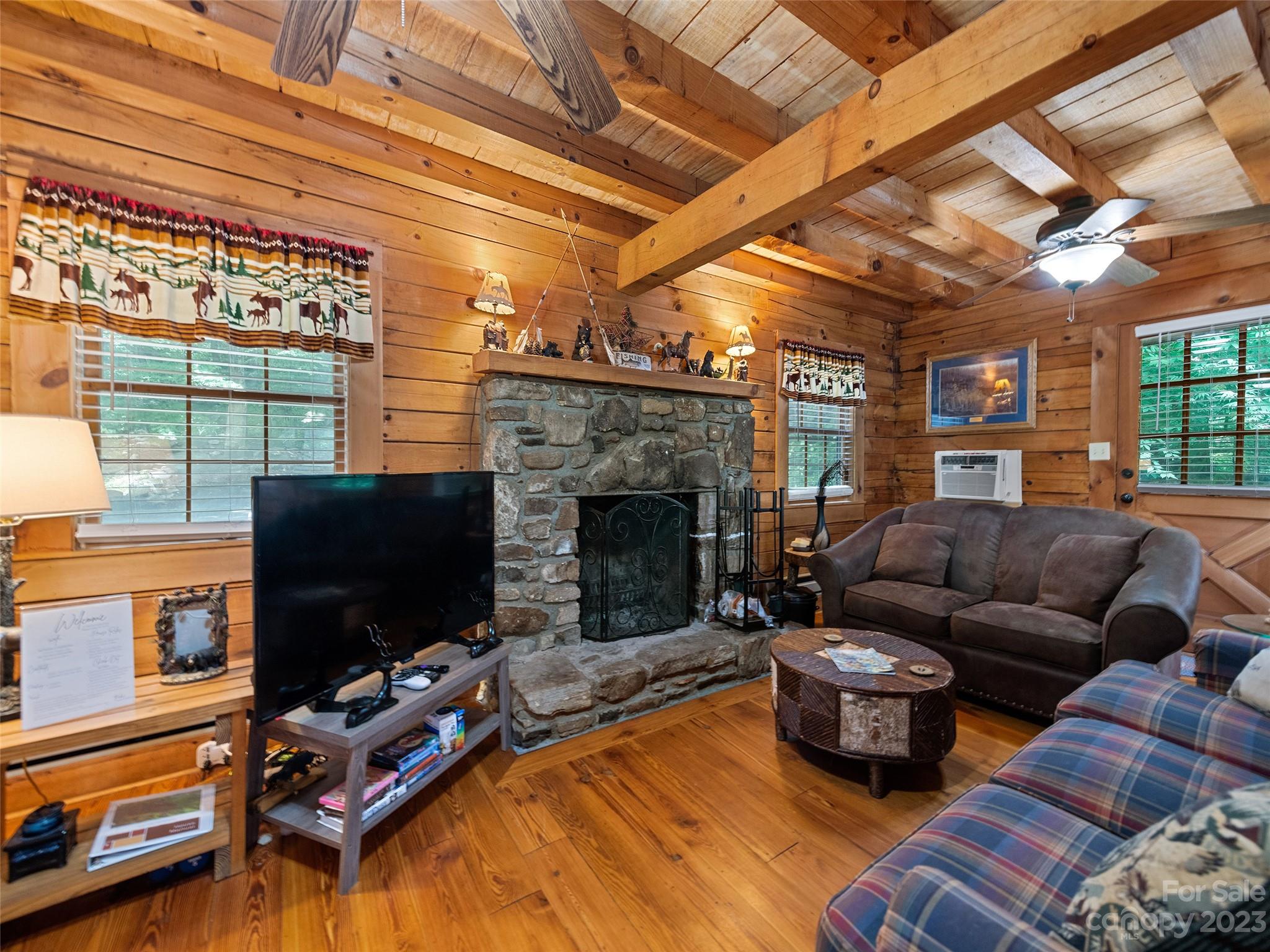 81 Railroad Grade Road Maggie Valley, NC 28751 - Photo 6 of 38 a living room with furniture a flat screen tv and a fireplace