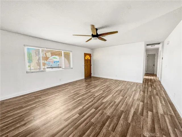 a view of empty room with wooden floor and windows