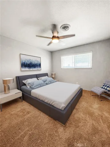 a spacious bedroom with a bed and a chandelier