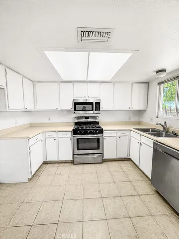 a kitchen with a stove sink and cabinets