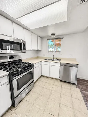 a kitchen with stainless steel appliances a sink a stove a microwave and cabinets